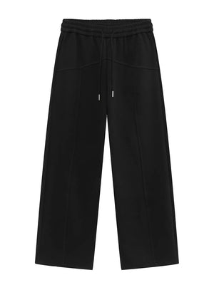 Black cotton sweatpants with drawstring waist and wide legs.