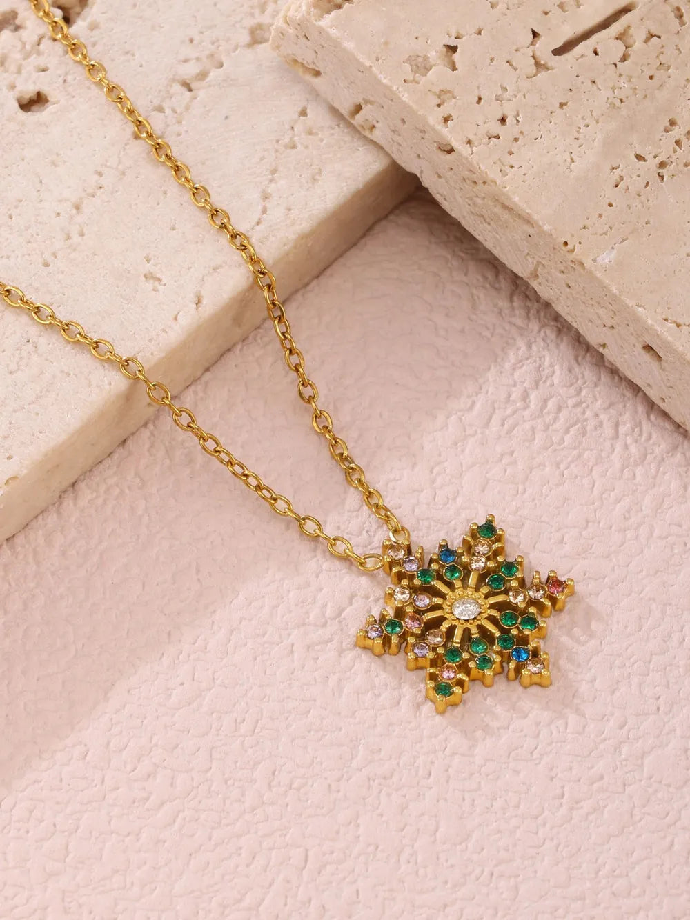 Celestial snowflake pendant necklace with mixed color gemstones on a gold chain