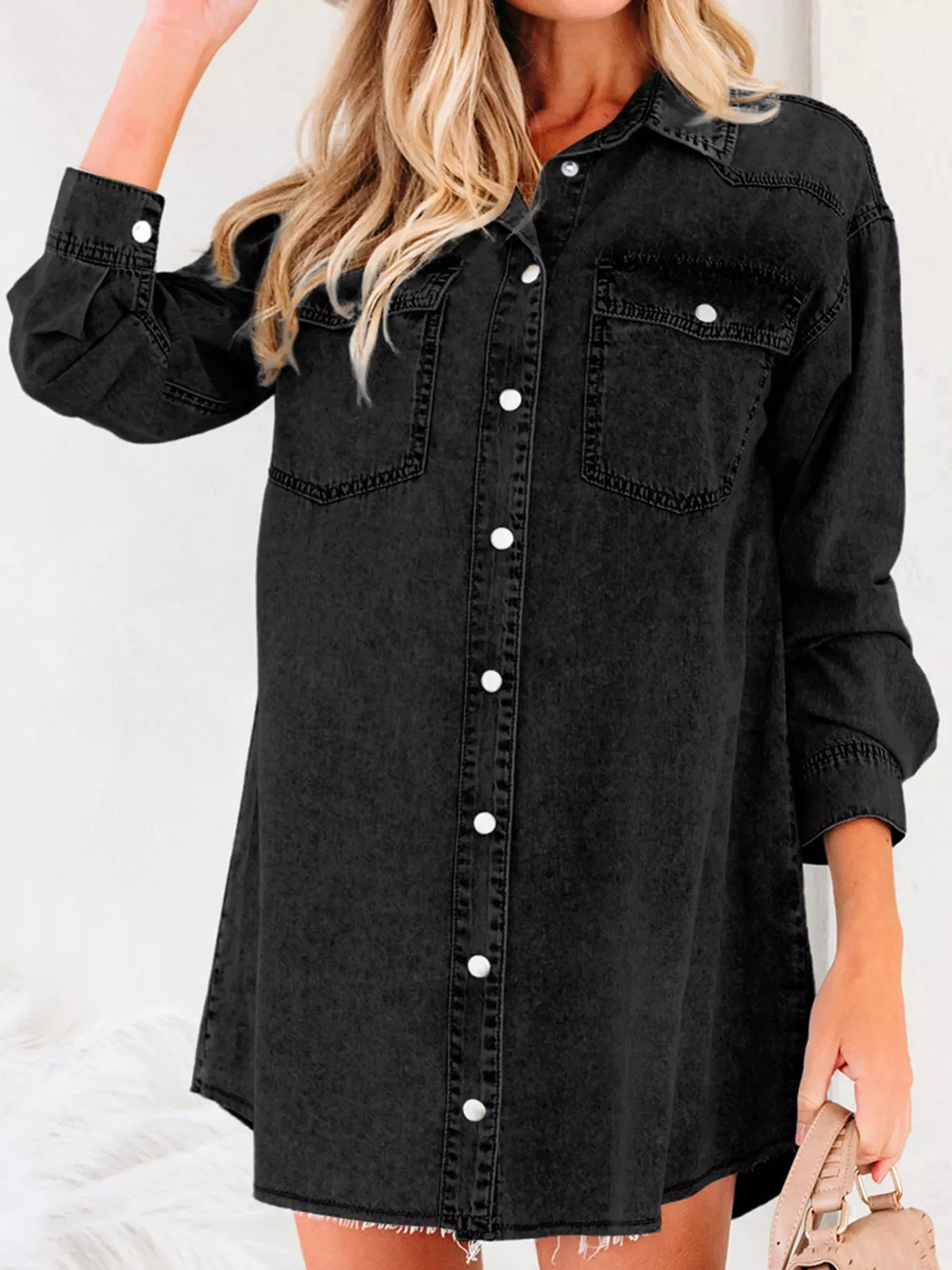 Black denim button-up dress with raw hem and chest pockets, casual style.