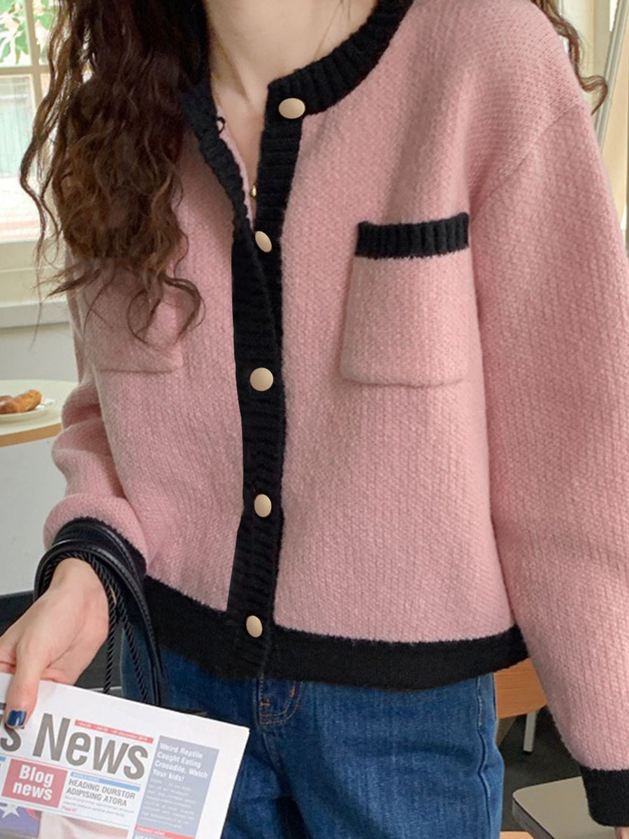 Pink acrylic cardigan with contrast black trim and buttons, featuring a pocket.