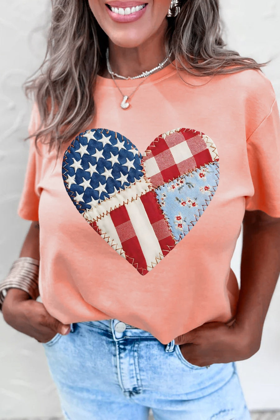 Peach t-shirt with a patriotic patchwork heart graphic on the front.
