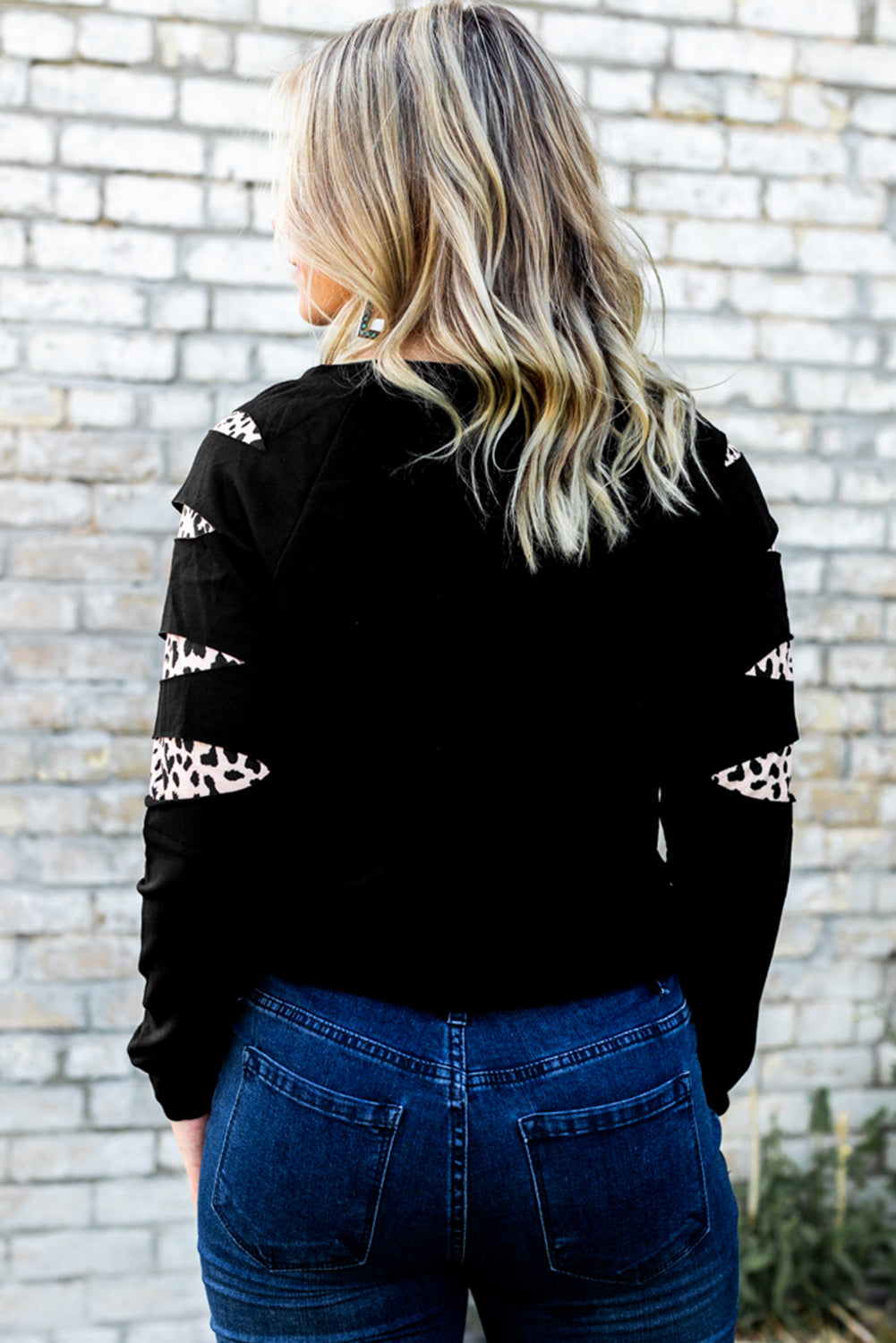 Black sweatshirt with cutout sleeves featuring a leopard print detail.