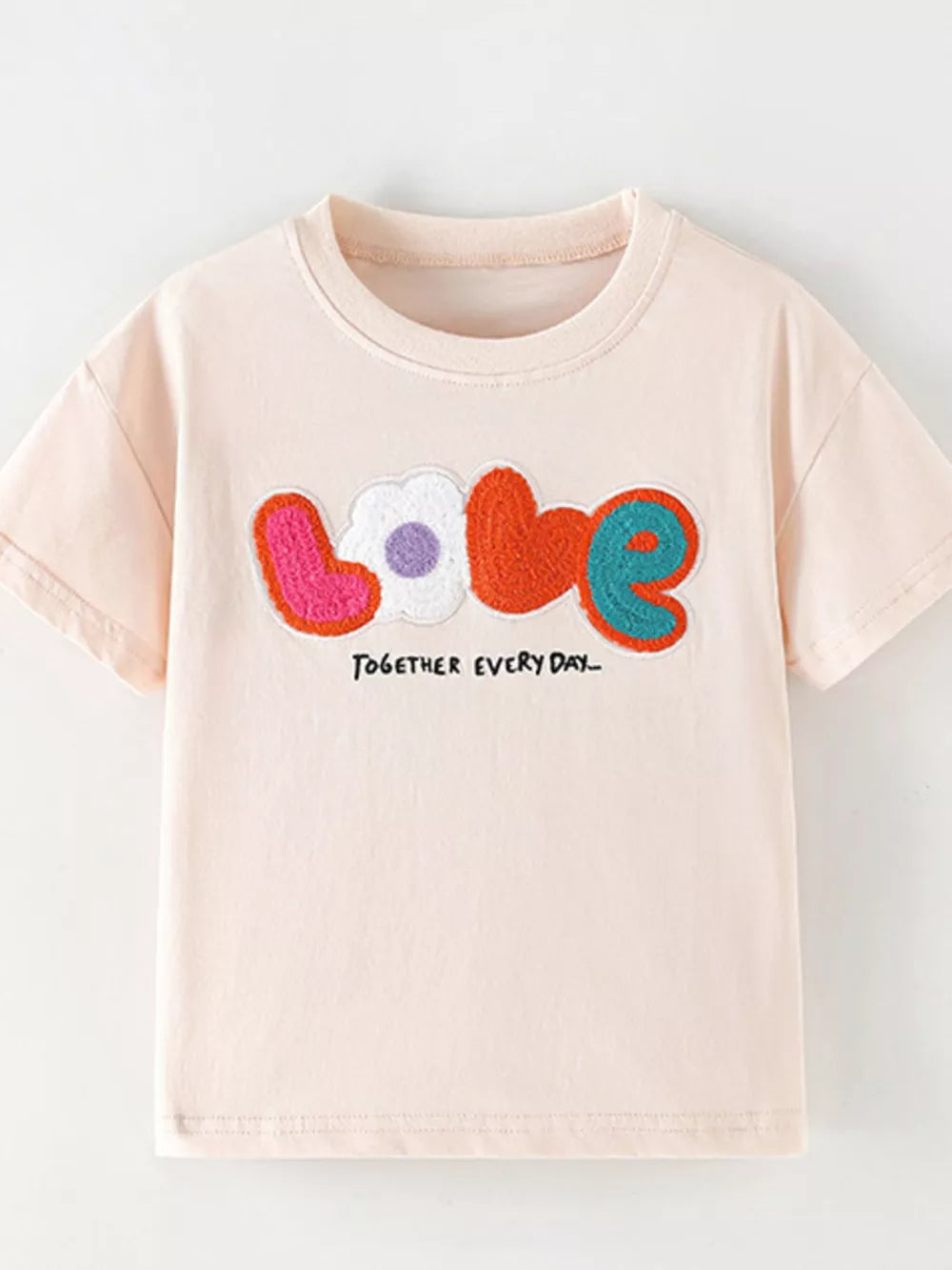 Toddler t-shirt in light pink cotton with colorful applique "love" graphic and text.