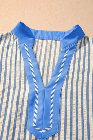 Vibrant stripe V-neck shirt with blue color block detail and decorative stitching.