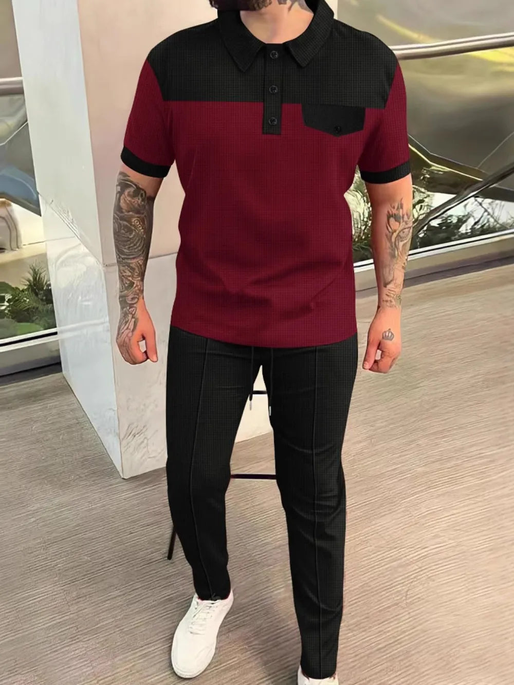 Burgundy and black colorblock polo shirt with black track pants.