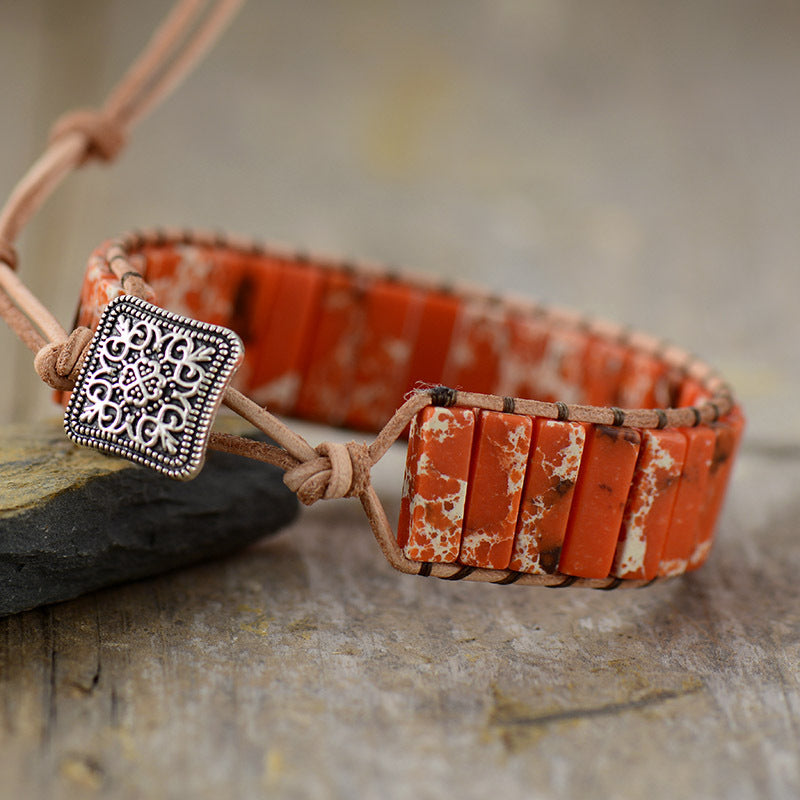 Orange jasper wrap bracelet with leather cord and silver charm.