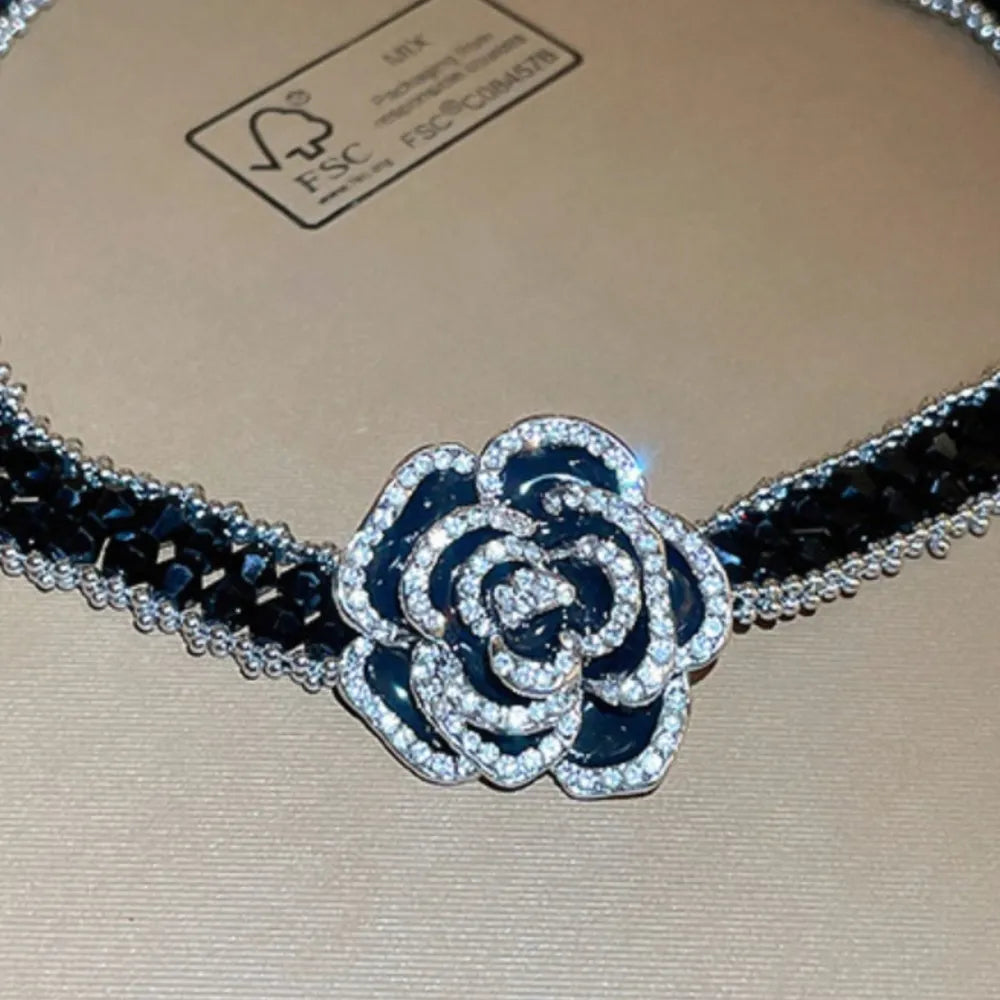 Black crystal rose choker necklace with silver trim and black enamel rose with crystal accents.