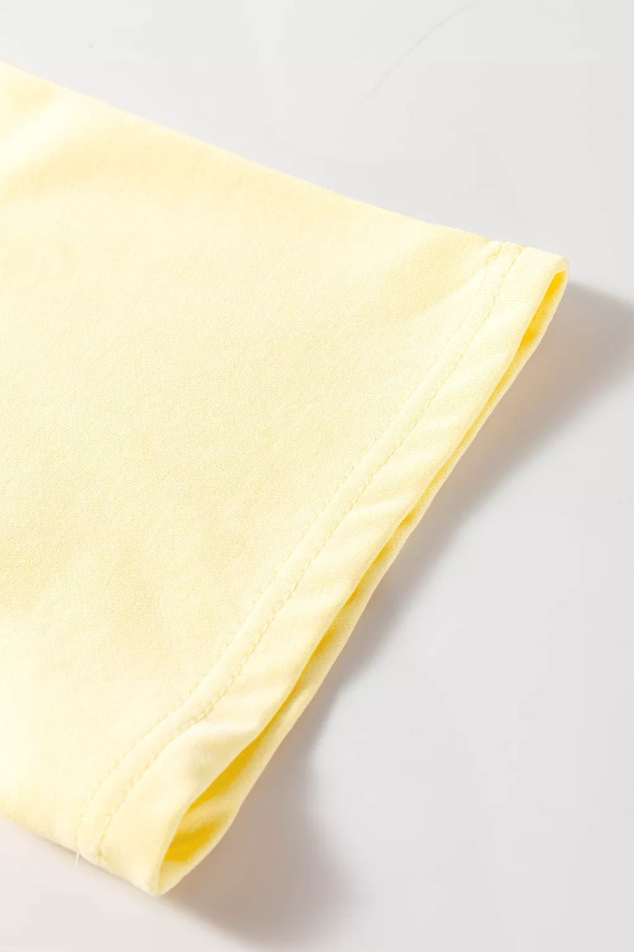 Light yellow t-shirt sleeve with double-stitched hem