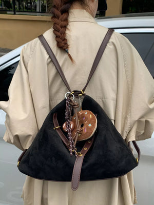Black hobo bag with adjustable strap and donut charm accessory.