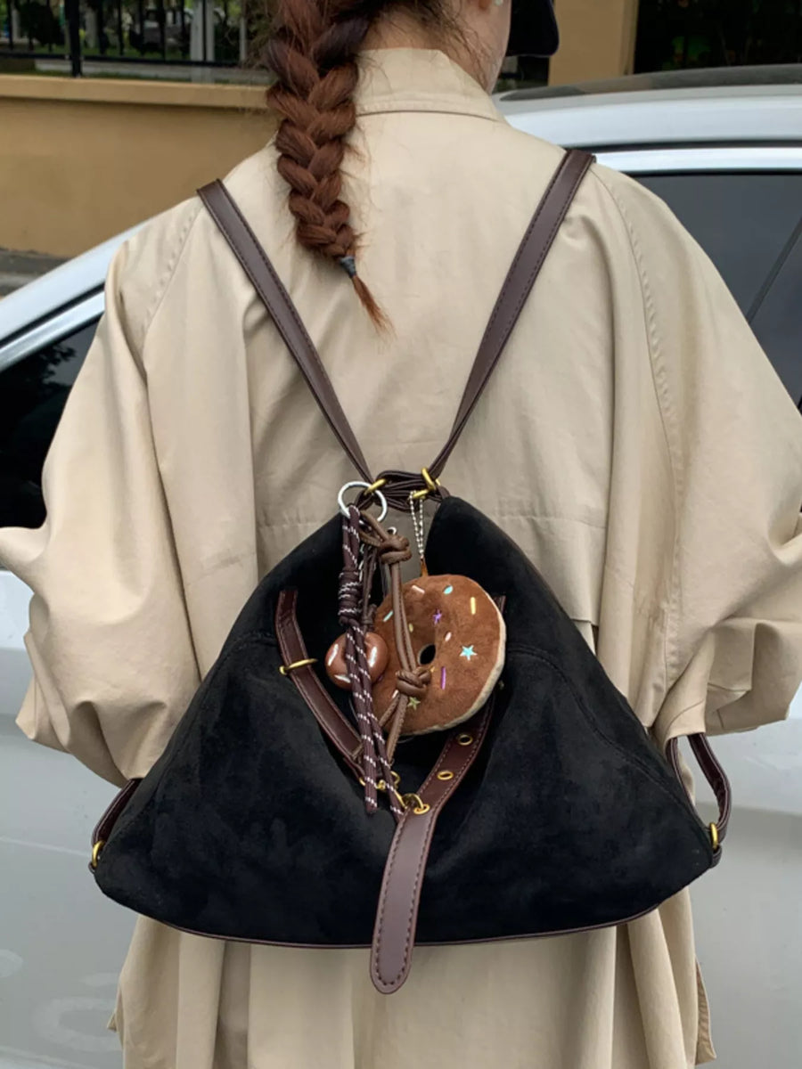 Black hobo bag with adjustable strap and donut charm accessory.