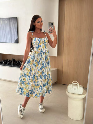 Floral tie-strap midi dress with blue and yellow print, square neckline, and A-line skirt.