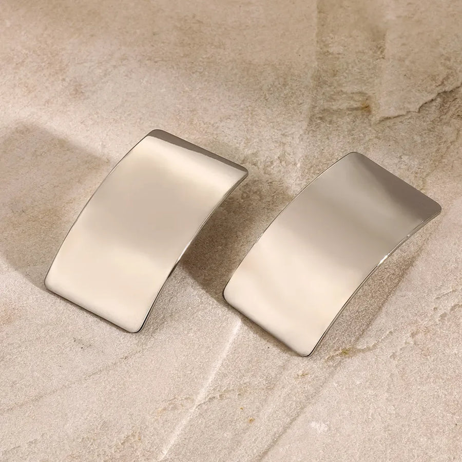Sculpted silver-tone statement earrings with a bold, casual style.