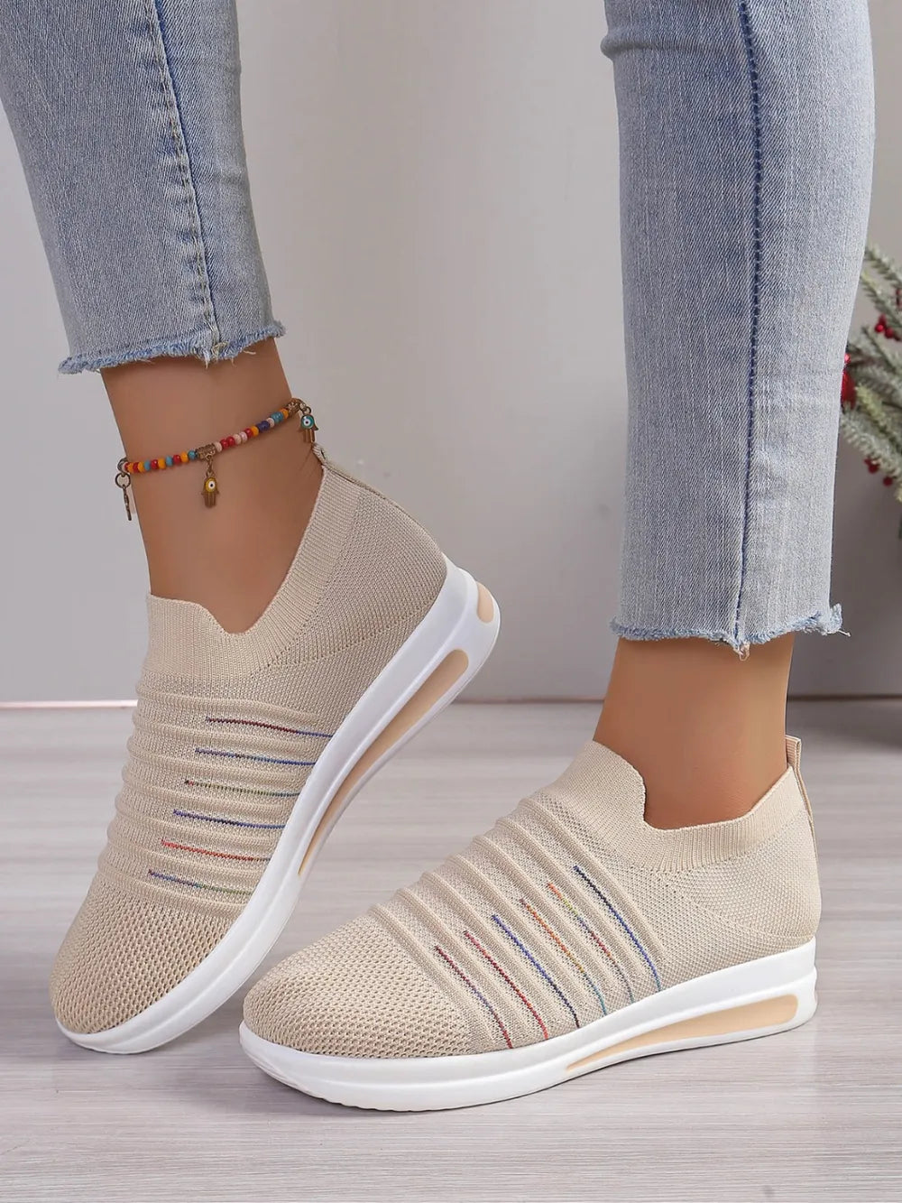 Striped knit slip-on wedge sneakers in light blue with rainbow stripe accents.