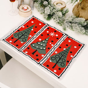 Red placemat with green Christmas trees and white polka dots