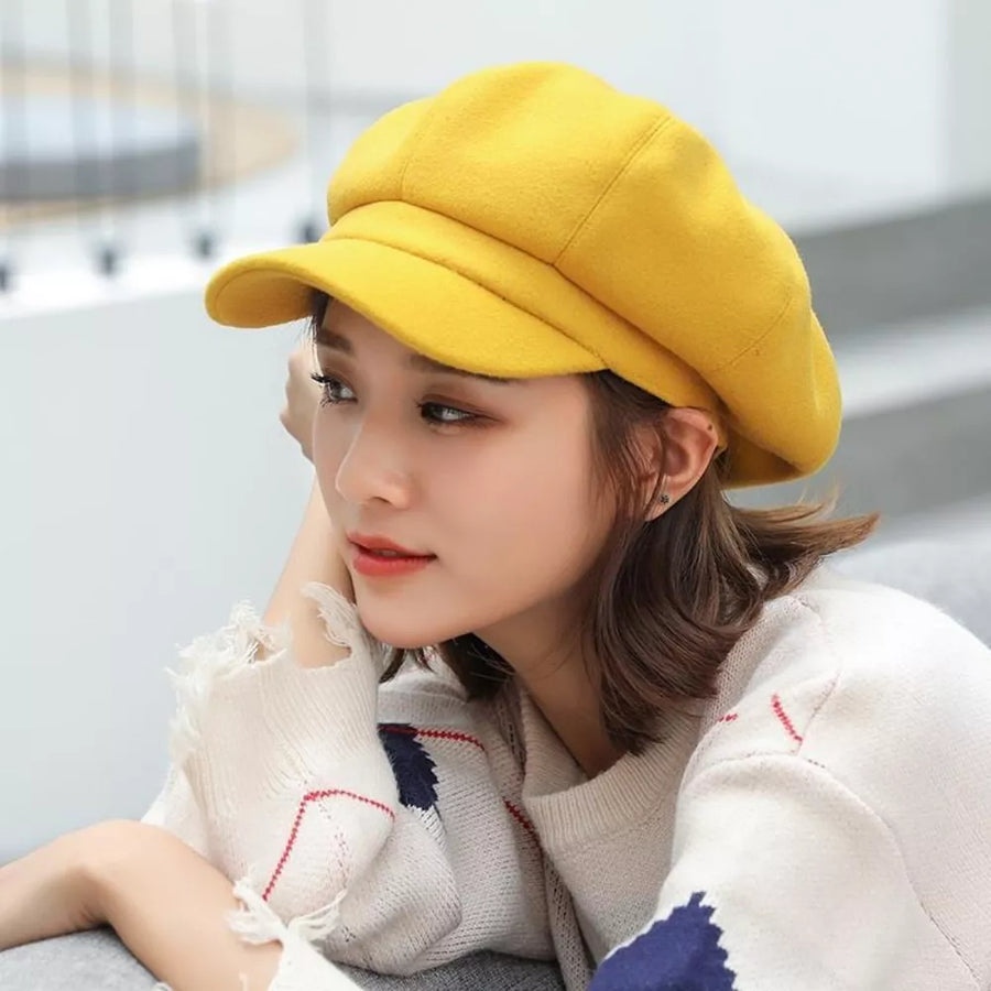 Yellow polyester beret with a brim, worn by a woman.
