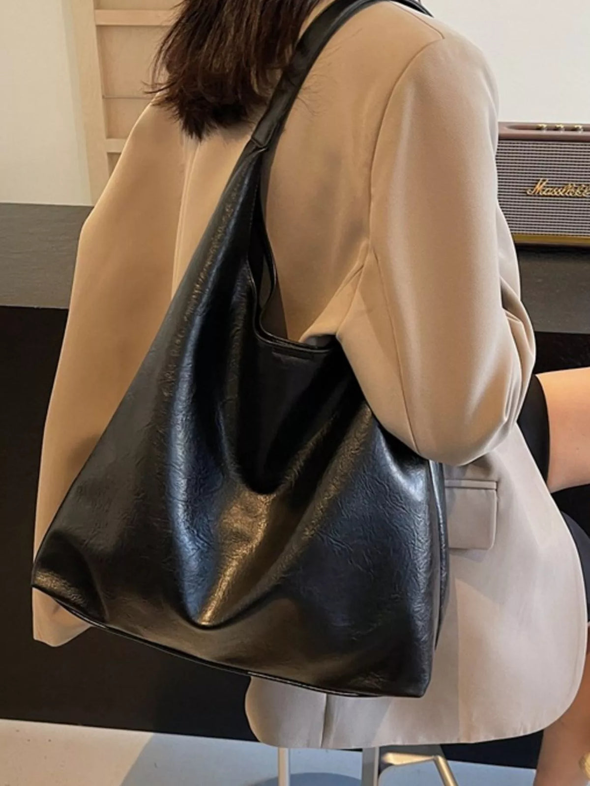 Black PU leather tote bag with a slouchy, sculptural shape and single strap.
