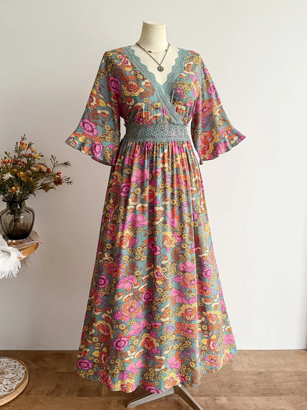 Maxi dress with floral print, lace trim, and surplice neckline.