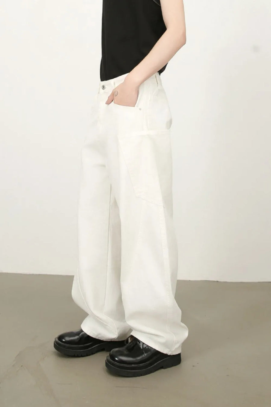 White wide leg trousers with sculpted pocket detail and a relaxed fit.