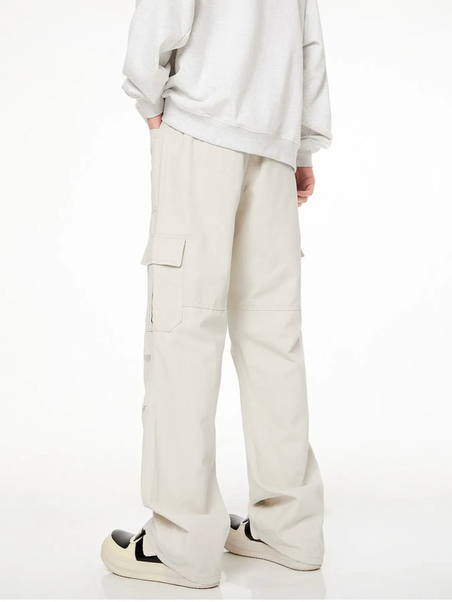 Men's loose fit cargo pants in creamy-white with multiple pockets.
