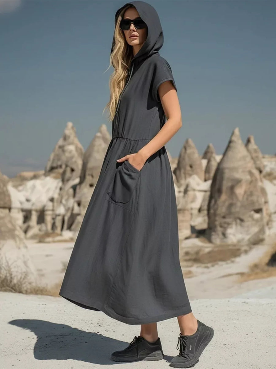 Grey hooded midi dress with short sleeves and functional pockets, styled casually.