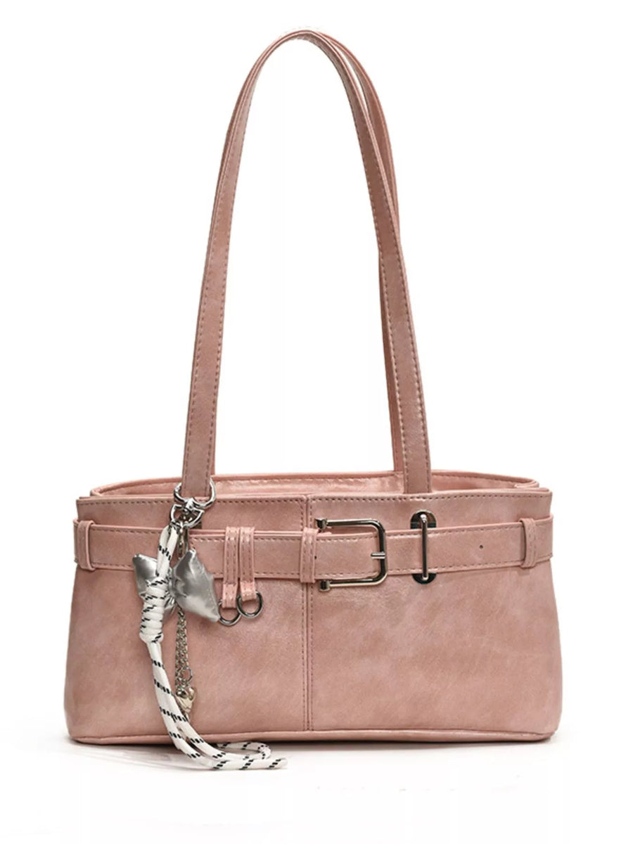 Blush pink shoulder bag with buckle detail and silver charm.