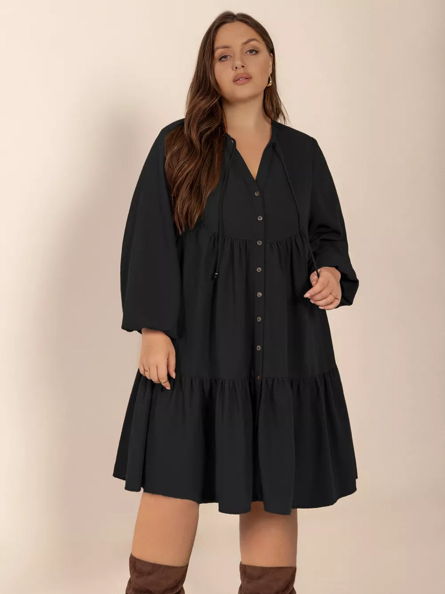 Black plus-size dress with balloon sleeves, tiered skirt, and button front.