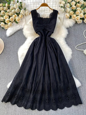 Black eyelet maxi dress with cutout detail and scalloped hem.
