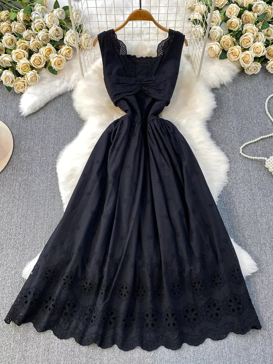 Black eyelet maxi dress with cutout detail and scalloped hem.