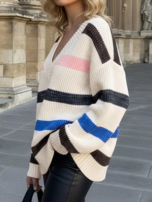 Oversized striped V-neck sweater in cream with black, brown, pink, and blue stripes.