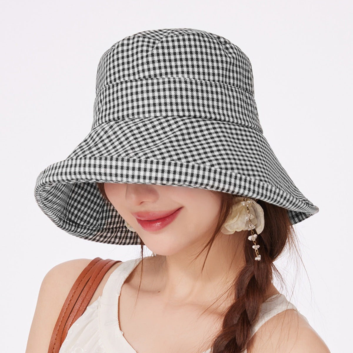 Gingham wide brim bucket hat in black and white checkered pattern.