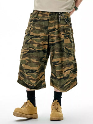 Oversized cotton camo cargo shorts in olive brown with multiple pockets and a chain detail.