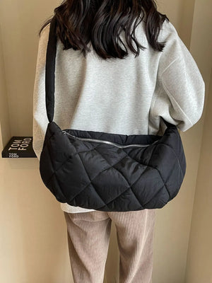 Black quilted crossbody bag with diamond pattern and silver zipper detail.