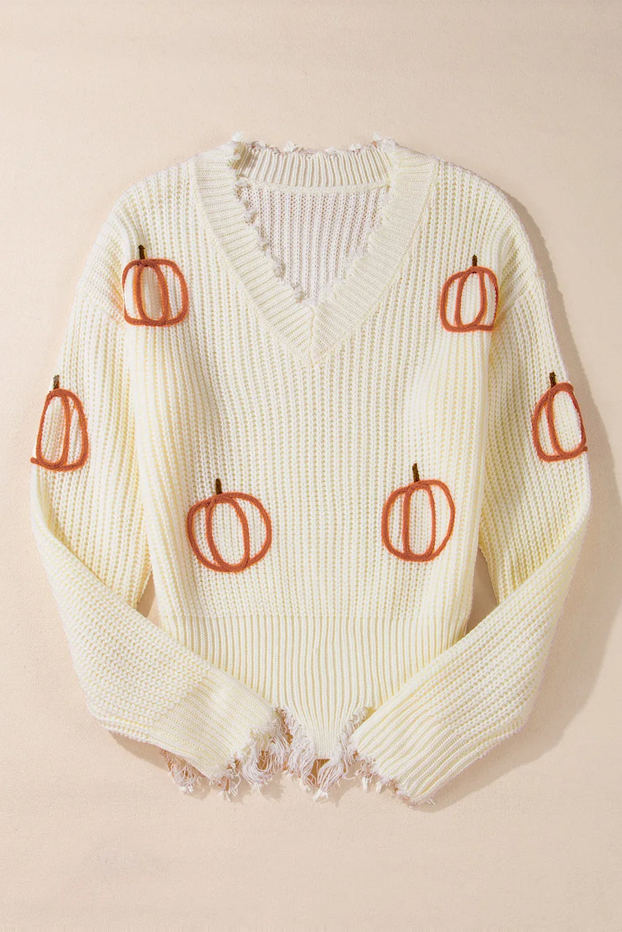 Beige distressed knit sweater with all-over pumpkin embroidery and frayed hem.