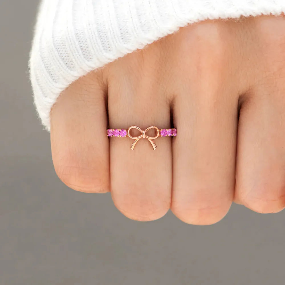 Rose gold ring with a bow and pink gemstones, 18K.