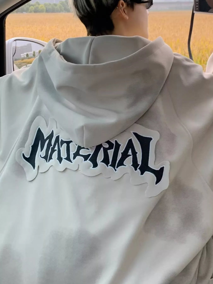 Oversized zip-up hoodie in apricot with a black graphic print on the back.
