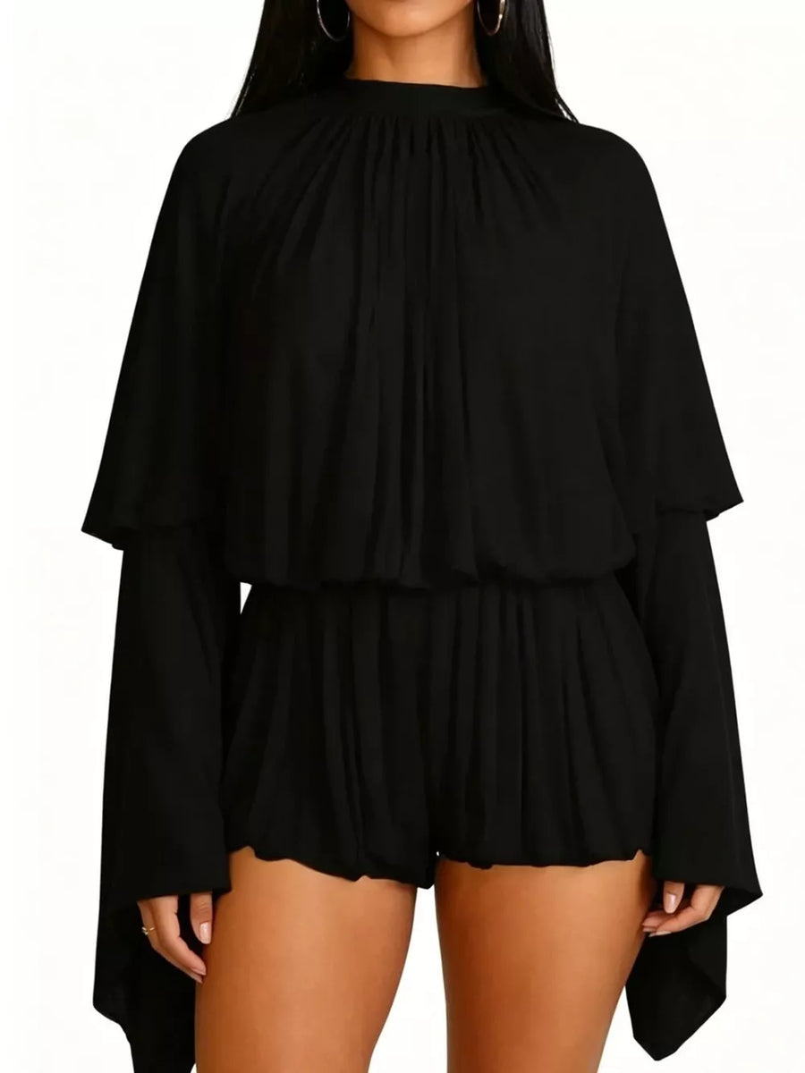 Black flowy romper with high neck, long bell sleeves, and elastic waist