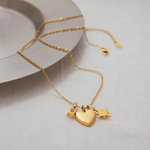 Gold dainty necklace with heart, star, and initial charms.