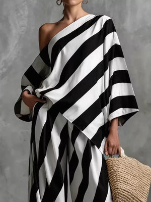 Black and white striped one-shoulder wide-leg jumpsuit with oversized sleeves.