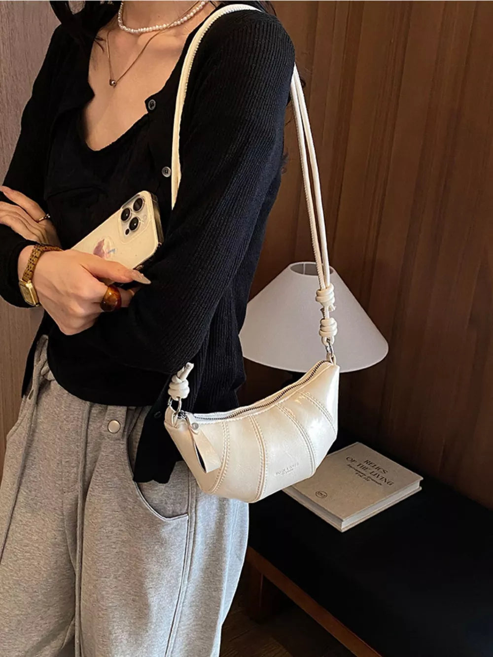 crossbody bag in ivory featuring stitched details and crescent fit