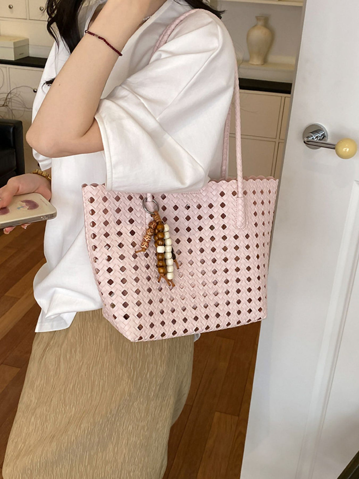 Pink handbag featuring woven design and geometric