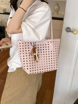 Pink handbag featuring woven design and geometric