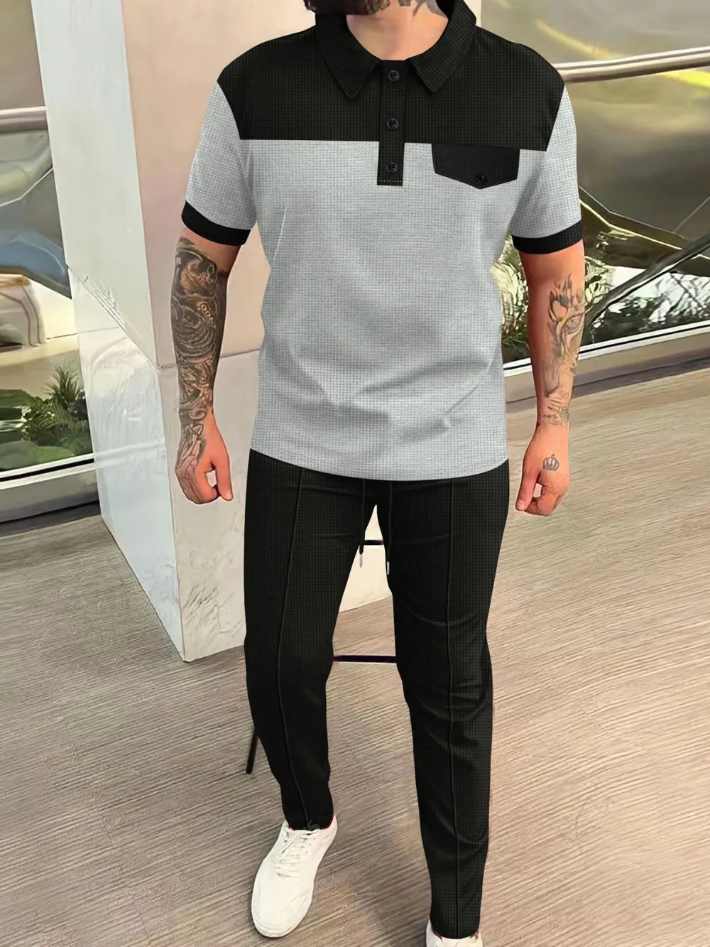 Colorblock polo shirt and track pants set in gray, black, and dark gray with a chest pocket.