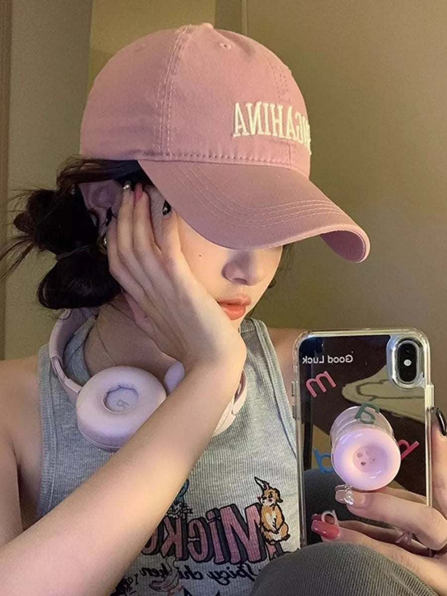 Pink cotton baseball cap with mirrored letter embroidery and curved brim.