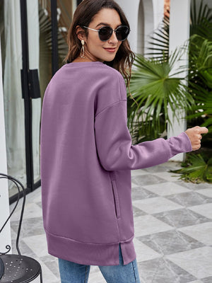 Tunic sweatshirt in Dusty Purple with crewneck, long sleeves, side pockets, and ribbed hem.