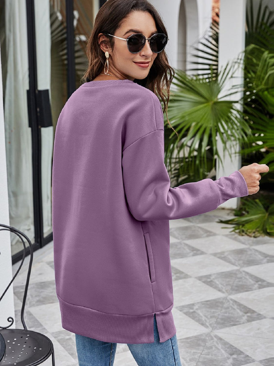Tunic sweatshirt in Dusty Purple with crewneck, long sleeves, side pockets, and ribbed hem.