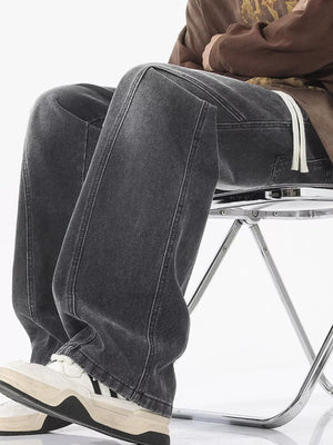 Dark gray relaxed fit wide-leg jeans with drawstring detail and white laces.