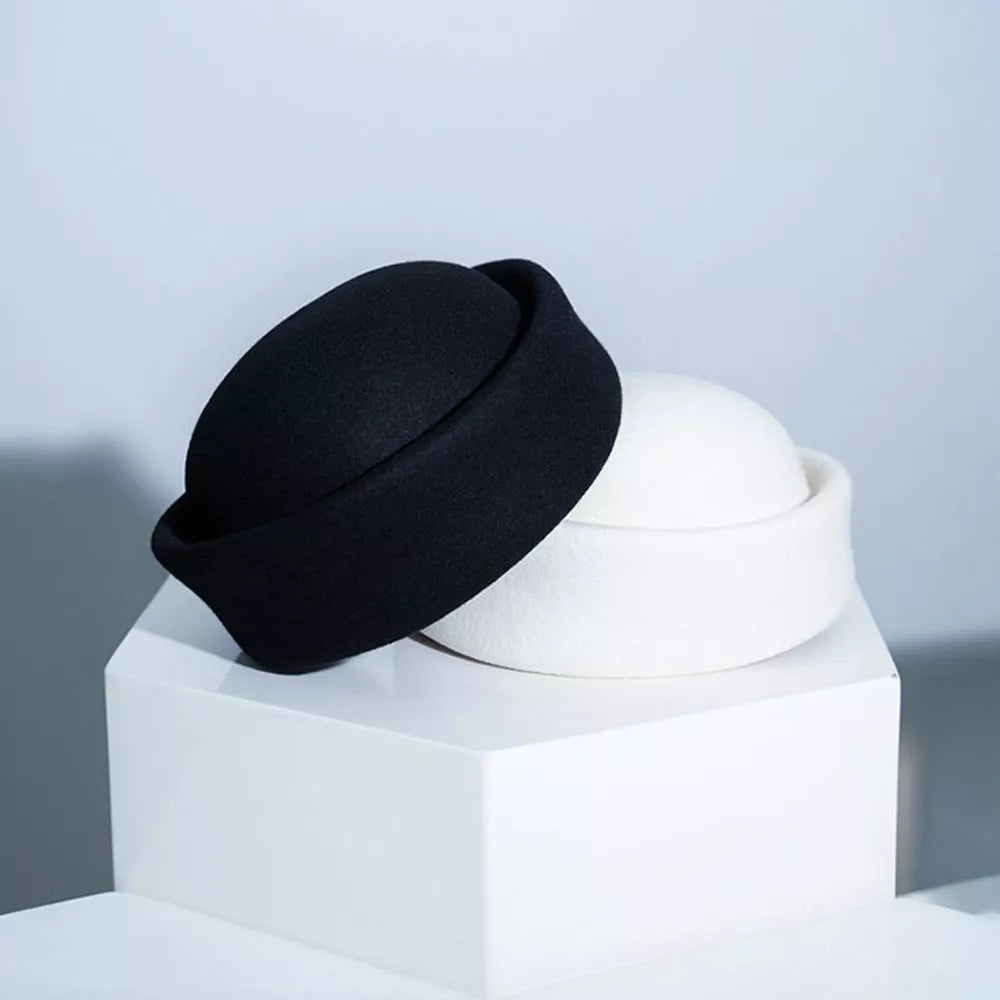 Elegant wool pillbox hat in black and white, chic winter accessory for women.