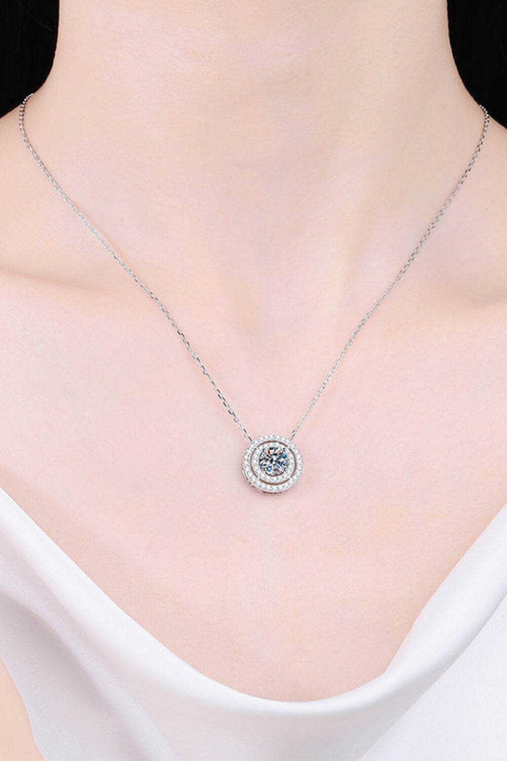 Silver halo diamond-framed pendant necklace with a central sparkling stone.