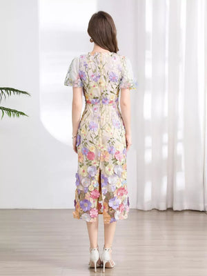 Sheath dress with colorful floral embroidery, short sleeves, and a midi length with a back slit.