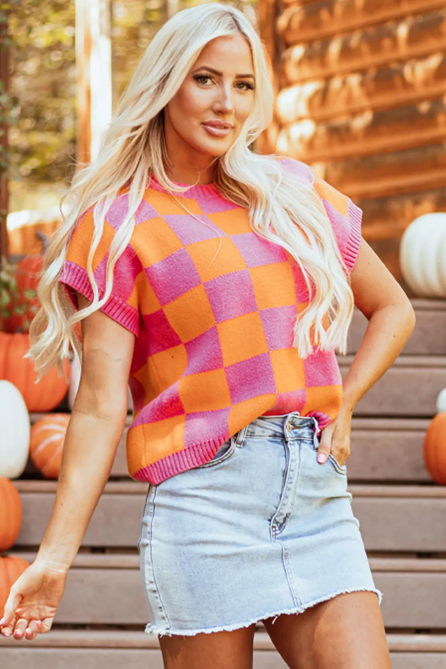 Checkerboard knit cap-sleeve top in plaid orange and pink with a crew neck.